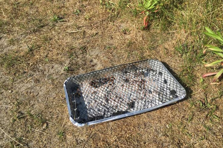 Spent barbecue on grass