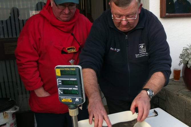 A flashback to 2013: Andrew Skeels and Ken Gainfort carefully weighing the fish