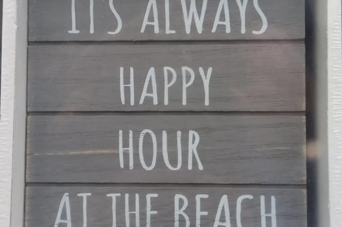 Sign: “It's always happy hour at the beach”