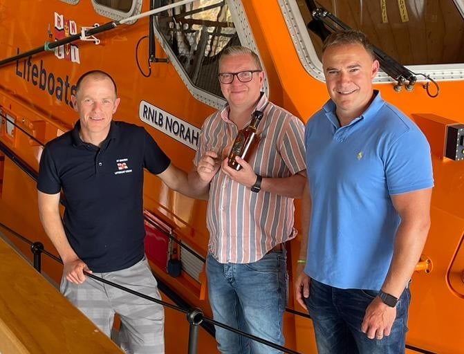 Coxswain Will Chant alongside Neil Walsh and Carwyn James of St Davids Gin and Kitchen