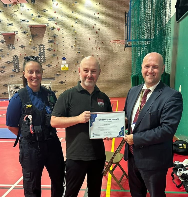 PCSO Laura Edwards, and PCC Dafydd Llywelyn presenting certificate to Chris McEwen of BOXWISE