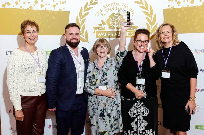 Receiving the award from the Mental Health & Wellbeing Wales Awards 2023 team representative are the Hywel Dda University Health Board team: Trystan Sion, Fiona Edwards, Stacy Baker and Cath Einon