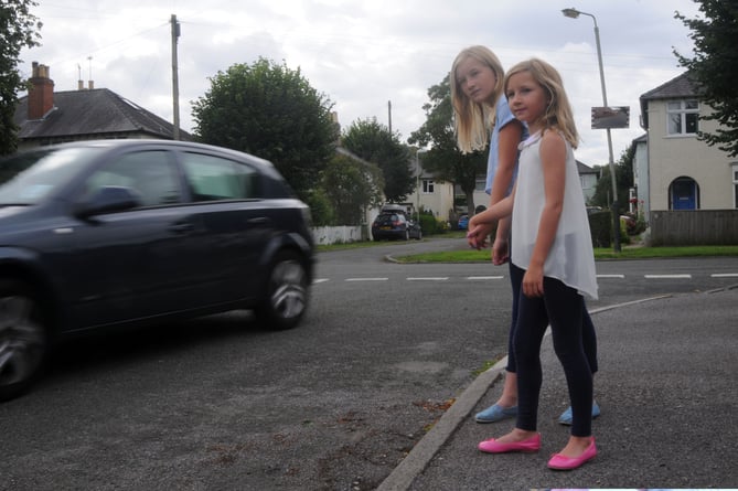 Charlotte and Emily watch a car speed by.