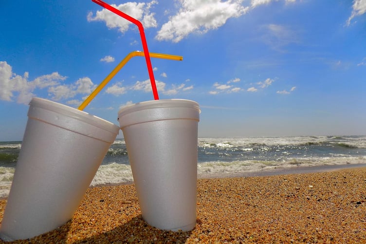 Polystyrene cups and straws on beach