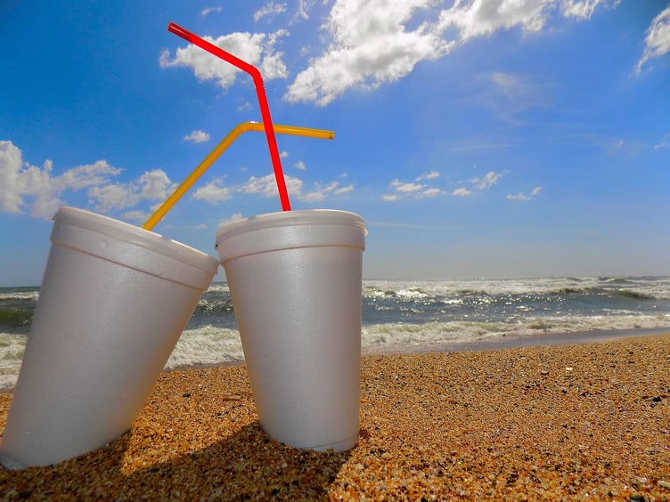 Polystyrene cups and straws on beach