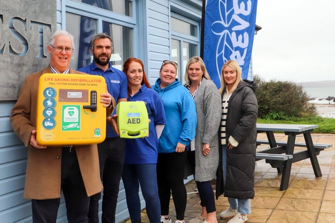 Valero Pembroke Refinery Public Affairs Manager Stephen Thornton presents a defibrillator to with Sam John, Natalie John & Lucy Garrett of the Forever 11 charity and Sheila & Ellie Griffiths of the Wavecrest Cafe at West Angle Beach