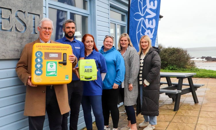 Valero Pembroke Refinery Public Affairs Manager Stephen Thornton presents a defibrillator to with Sam John, Natalie John & Lucy Garrett of the Forever 11 charity and Sheila & Ellie Griffiths of the Wavecrest Cafe at West Angle Beach