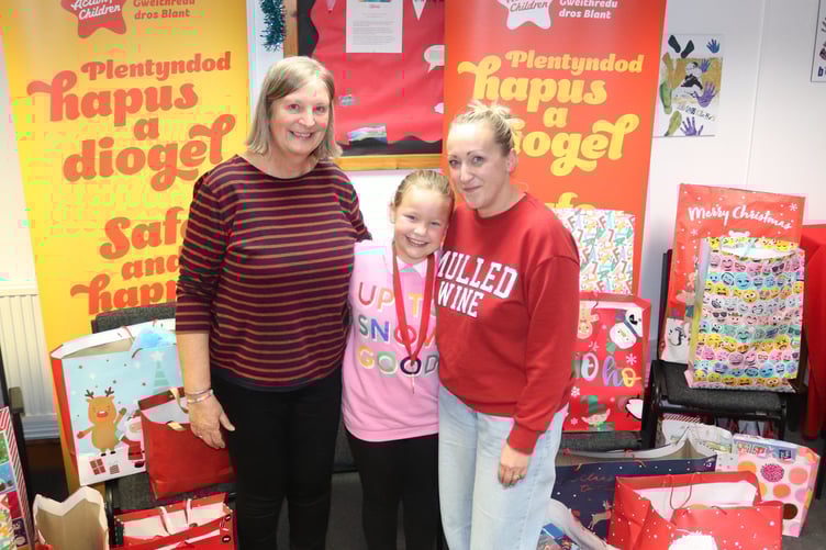 Sue Marsden, Grace and Kirsty with the presents in Llanelli office of Action for Children