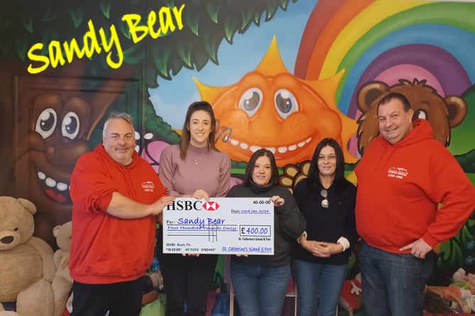 Sandy Bear’s Hannah Beer and Michelle Joseph being presented a cheque for £400 by volunteers at St. Catherine’s Island and Fort.