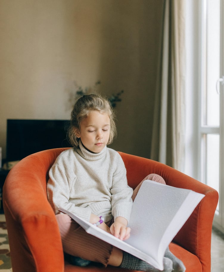 Blind child reading braille book
