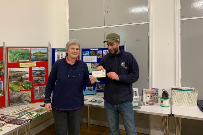 Clare Walker, Chair of the South Pembrokeshire Local Group of the Wildlife Trust, presents Trust Reserves Manager, Nathan Walton, with a cheque for £500 