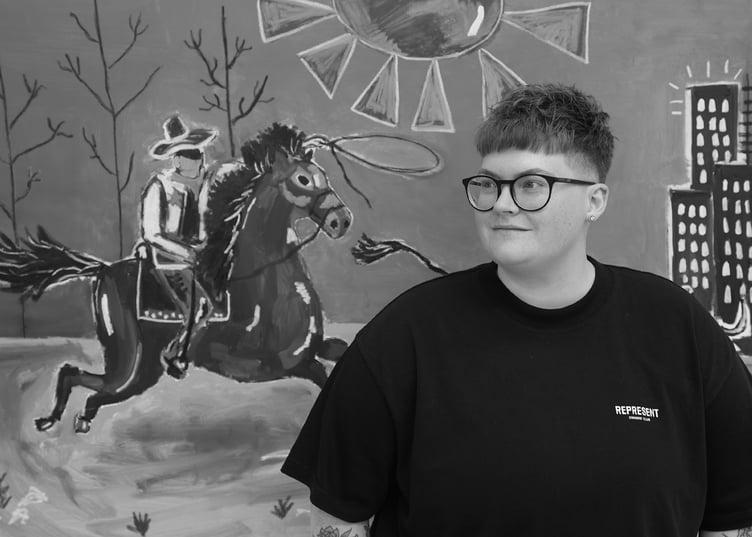 Caitlin Flood-Molyneux with one of her selected artworks from her tour ‘Going Away in Order To Return’