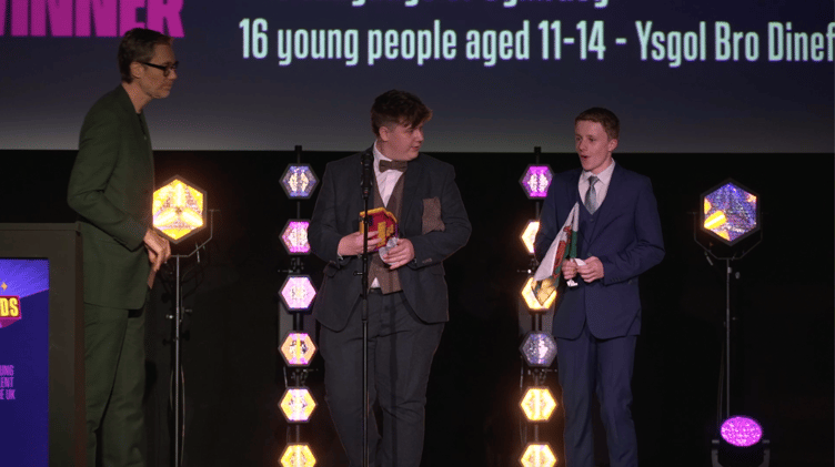 Taran and Joseph receive the award from actor Stephen Merchant