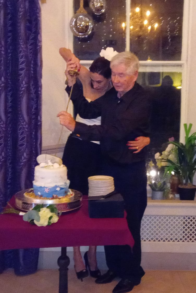 Local author Cyril James Morris, Lt Cdr, Rtd, and his wife Louise using Cyril’s ceremonial sword to cut their wedding cake during their reception at The Belgrave Hotel, Tenby.