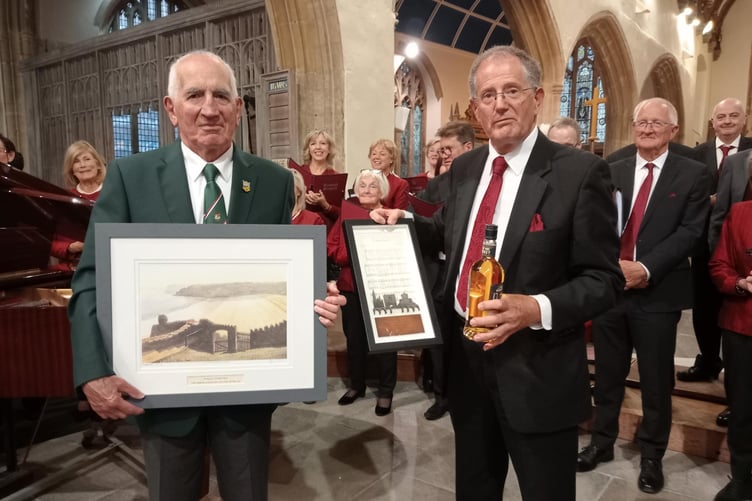 Choir chairmen Huw Morgan (left) and Vincent Moore exchange gifts.