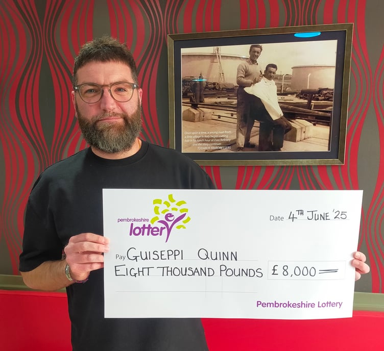 Guiseppi Quinn with the £8,000 prize cheque