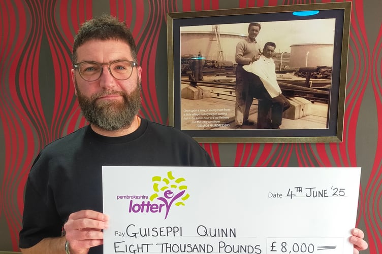 Guiseppi Quinn with the £8,000 prize cheque