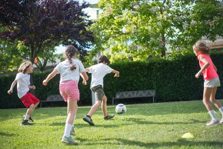 Children playing football in park