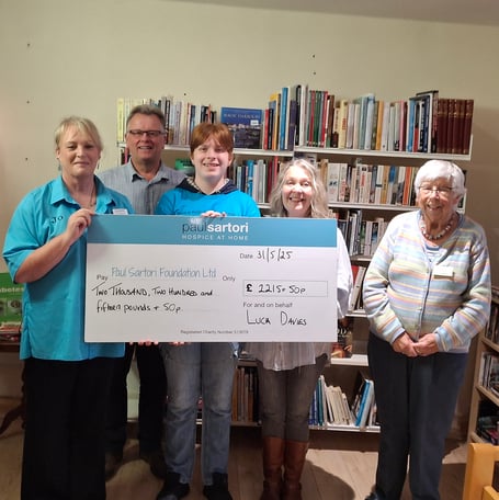 Presenting the cheque is Luca Davies with Joanne Lutwyche, Events and Fundraising Officer for Paul Sartori, Narberth Sartori Store Manager Derrick Noakes, and the volunteers from the Narberth store where Luca volunteered.