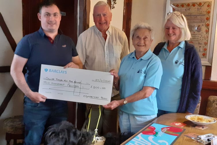 Adge John, guide dog Skip, Eva Rich and Sheila Ravenscroft receiving the donation from Clynderwen YFC Show Committee.