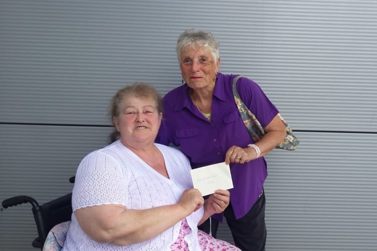 Summerhill WI treasurer Linda Brown handing the raffle proceeds to Rev'd Patrica Rogers of Haverfordwest Street Pastors