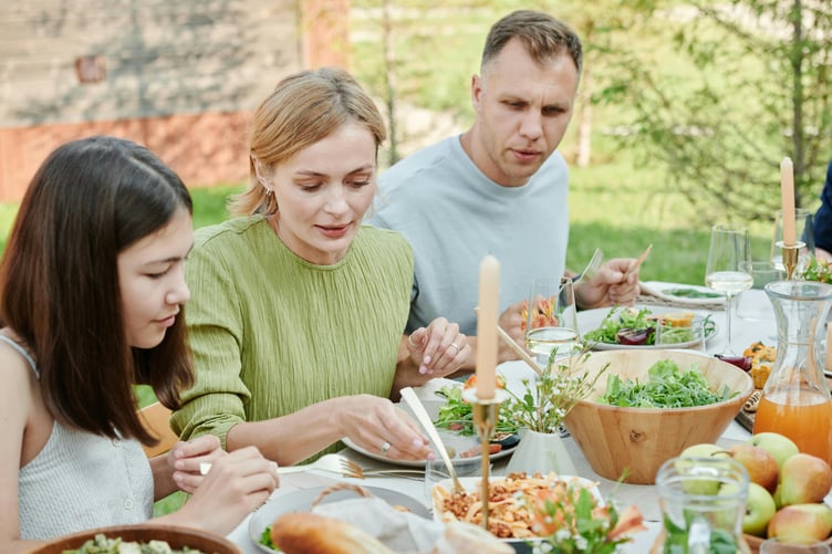 Family dining on fruit and vegetables outside