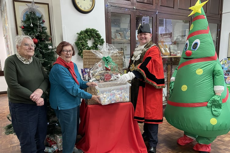 Pembroke Mayor Cllr Gareth John drawing the winning ticket for the hamper with its organisers Mrs Mary Willington and Mrs June Wilcocks