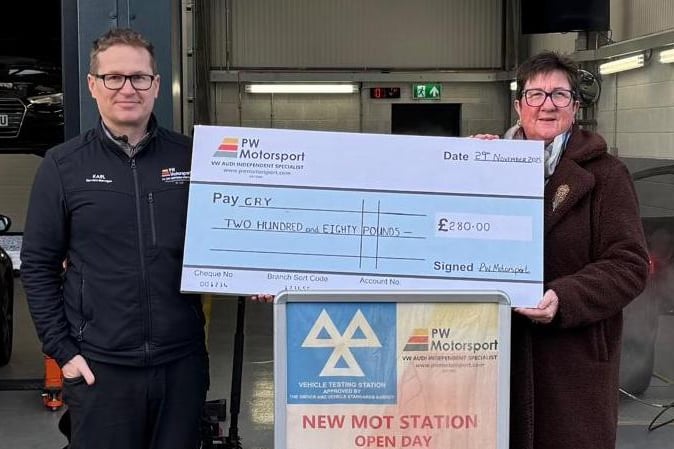 Karl Gos presenting a cheque to Gwenfair Mason in behalf of CRY