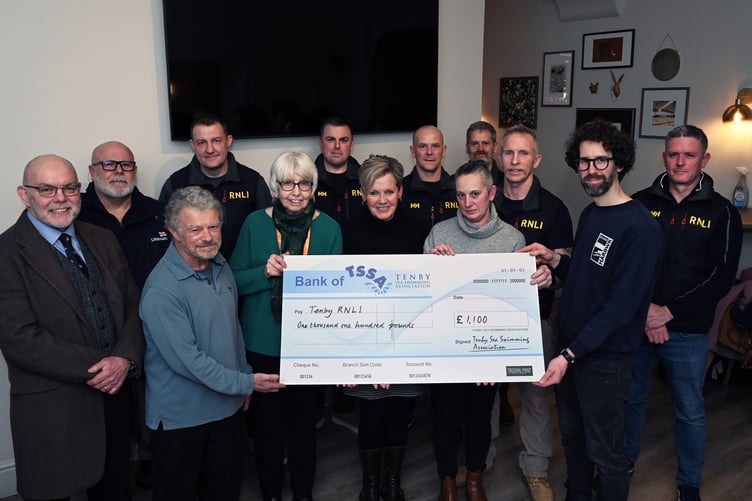 The Tenby RNLI cheque is received by coxswain Gary Waring and crew; station manager Carl Evans and branch fundraising chairman Nicole Evans.