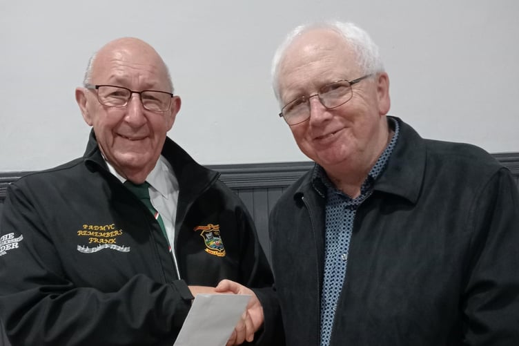 Choir Secretary Dave Powell receives a donation from Father Larry White